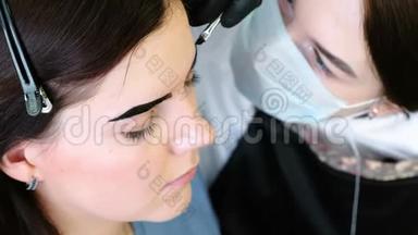 眉毛矫正。 美容师用刷子在客户`眉毛上<strong>涂油漆</strong>。 侧视。